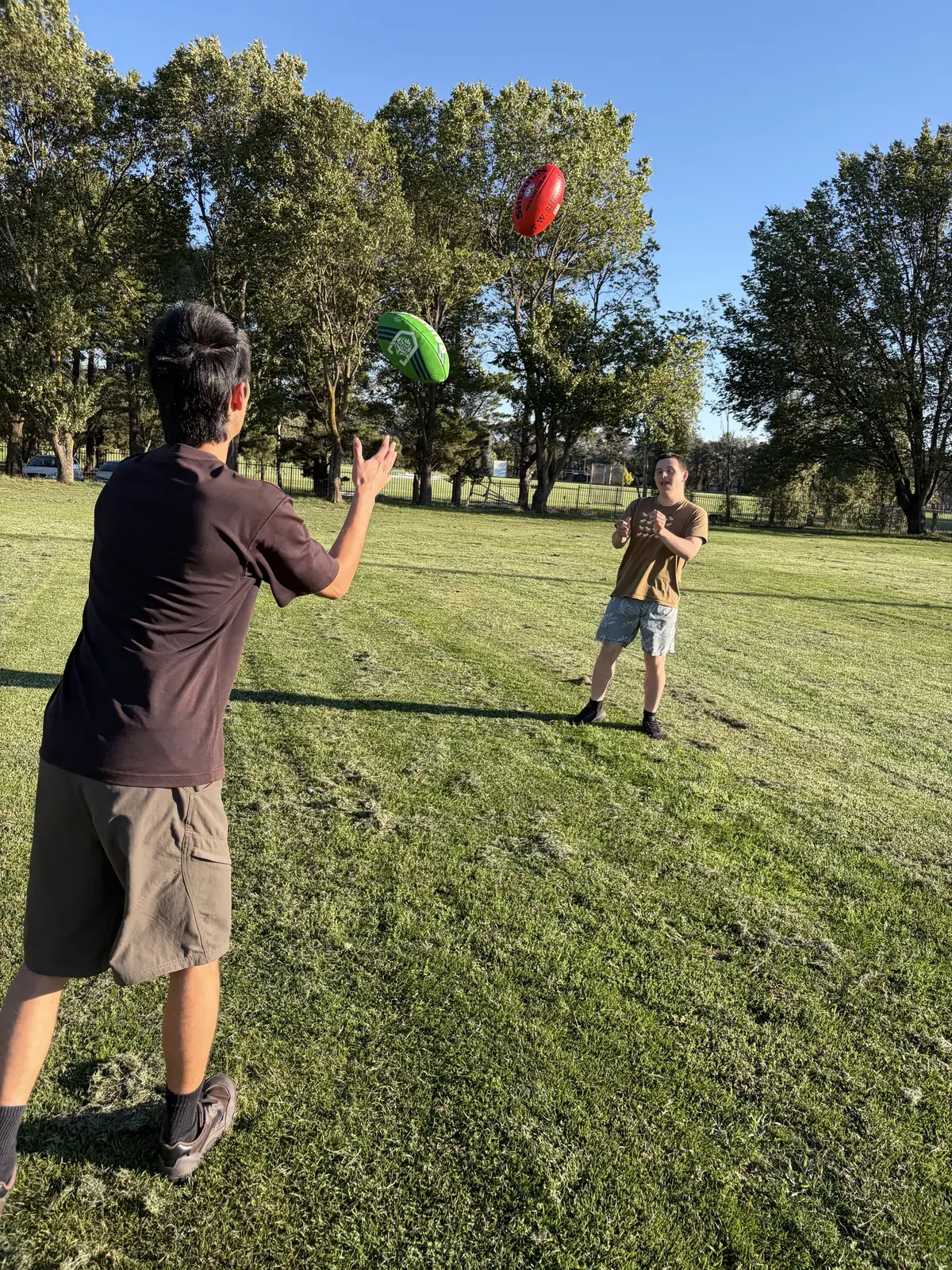 Field Day support worker playing catch outdoors with a participant