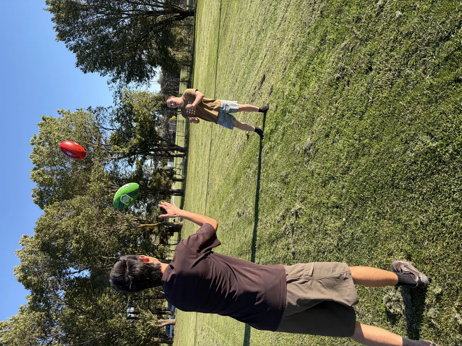 Support worker and young person playing catch outdoors