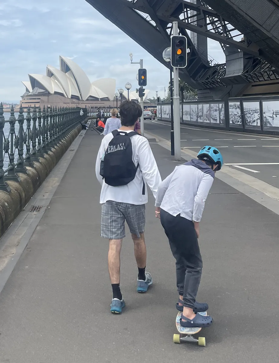Support worker and young person skateboarding together